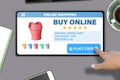 Hand with tablet pc tapping button place order on modern table background - online shopping technology concept