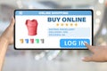 Hand with tablet computer tapping the button log in on bokeh business background - online shopping technology concept