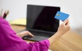 Online Shopping. Woman holding credit card and using laptop with blank screen Royalty Free Stock Photo