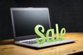 Online store sale campaign ad. Carboard paper letters on laptop.