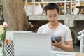 Online studying concept the man in plain white T-shirt feeling quite happy and holding the calculator for calculating numbers in Royalty Free Stock Photo