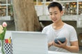 Online studying concept the man in plain white T-shirt feeling quite happy and holding the calculator for calculating numbers in Royalty Free Stock Photo