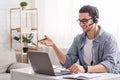 Online teacher and work from home. Guy in glasses and headset talking with student Royalty Free Stock Photo