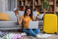 Online tickets booking. Excited black woman with passport and airplane tickets using laptop to buy tourist vacation Royalty Free Stock Photo