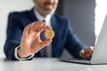 Online Trading. Smiling Businessman In Suit Sitting At Desk And Holding Bitcoin Royalty Free Stock Photo