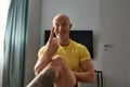 Online training. Mature fitness instructor, male personal trainer gesturing at camera and smiling while conducting