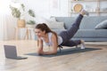 Sporty Girl Exercising at Home, using laptop Royalty Free Stock Photo