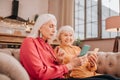 Two pleasant-looking elderly grey-haired women looking involved