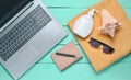 Online work at a beach resort. Laptop, towel, notepad, sunglasses, shell, sunblock, top view, flat lay.