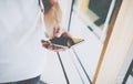 Online world. Hipster using modern smartphone in contemporary cafe. Holding mobile phone hand and typing message Royalty Free Stock Photo