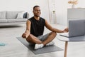 African Man Doing Yoga Online Meditating Sitting At Laptop Indoor Royalty Free Stock Photo