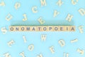 Onomatopoeia figure of speech concept in English grammar class lesson. Wooden blocks typography flat lay