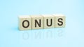 wooden blocks with the word ONUS, blue background Royalty Free Stock Photo