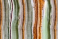 Onyx gemstone texture close up. Green, white, brown and orange stripes. Natural stone mineral background