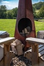 ood butning area with little stove and two wooden chairs Royalty Free Stock Photo