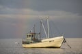 Ood fishing boat with birds and rainbow background