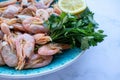 ÃÂ¡ooked shrimp with parsley and lemon in a blue ceramic bowl on a white marble table background. Healthy Mediterranean seafood. Royalty Free Stock Photo