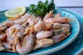 ÃÂ¡ooked shrimp with parsley and lemon in a blue ceramic bowl on a white marble table background. Healthy Mediterranean seafood. Royalty Free Stock Photo