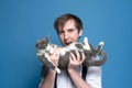 ooling around man holding cute gray and white cat on back and showing as if about going eat cat Royalty Free Stock Photo