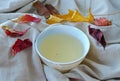 Oolong Chinese green tea on a white plate with autumn leaves on linen background