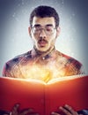 Oooh, I didnt see that one coming. A cropped shot of a young adult reading a book with glowing pages. Royalty Free Stock Photo