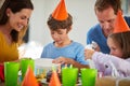 Oooh, what is it. a little boy opening his birthday presents surrounded by his family. Royalty Free Stock Photo