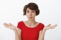 Oops bummer not big deal. perplexed careless relaxed cute awkward attractive woman short haircut pouting shrugging hands