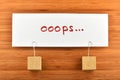 Oops, one paper note with holders isolated on wooden background