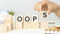 Oops sign on wooden cubes. Beautiful white background