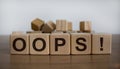 Oops sign on wooden cubes. Wooden table. Beautiful white background, copy space. Concept