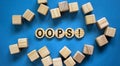 Oops sign on wooden cut circles. Wooden cubes. Beautiful blue background, copy space. Concept Royalty Free Stock Photo