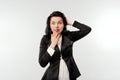 Coy cute young businesswoman in black formal jacket white shirt covering mouth and looking guilty, did something awkward, standing Royalty Free Stock Photo