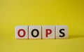 Oops symbol. Concept word Oops on wooden cubes. Beautiful yellow background. Business and Oops concept. Copy space