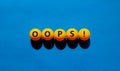 Oops symbol. Orange table tennis balls with the words `oops`. Beautiful blue background, copy space. Warm sunshine. Business and