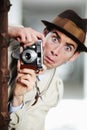 Oops, theyve seen me. Private detective capturing a photo suspiciously from around a corner while using a retro camera.