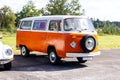 Oostmalle, Belgium - August 19 2023: An orange and white vintage old timer volkswagen split bus, camper, minivan or minibus