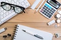 Op view of modern office desk table workplace with computer keyboard, glasses, calculator, pen, pencil and memory stick on wooden Royalty Free Stock Photo