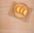 Op view vanilla cake roll on wooden dish with wooden spoon,fork on wooden background