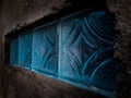 Opaque glass blocks in a gritty, textured wall, bathed in deep, mysterious blue light. Royalty Free Stock Photo