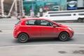 Opel Corsa D on the city road. Fast moving car on Moscow streets. Red vehicle driving along the street in city with blurred