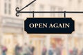 Open again sign board against open shop windows background. Restarting business after coronavirus quarantine lockdown Royalty Free Stock Photo