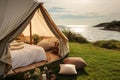 Open-air glamping tent with a luxurious bed, nestled in a lush seaside meadow at golden hour. Camping with luxury