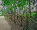 Open air museum on the island of Seurasaari in Finland. Pedestrian path along a hand-made wooden fence