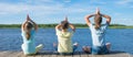 In the open air, on the pier, near the water the company of children is engaged in relaxation in the form of yoga