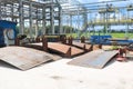 An open-air production site at an industrial plant, a workshop for welding large iron metal barrels and containers made of metal