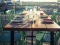 Wooden table with green chairs-restaurant in open space on the background of berth with Yachts. Rendering.