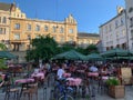 An open-air restaurant, tables and chairs arranged outside under umbrellas in the city center, Lviv restaurants