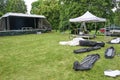 Open air stage, pavilion for the sound system, tent poles and canvas in bags for setting up a music festival on the green meadow