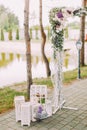 Open air wedding composition. The part of the flower wedding arch and vintage boxes with candles.