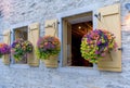 Open air windows with yellow shutters and beautiful hanging bask Royalty Free Stock Photo